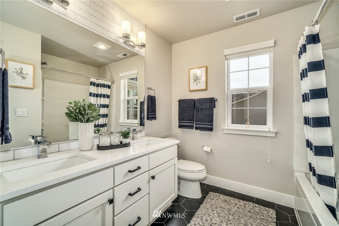 3318 238th Place Southeast Bothell, WA 98021 - Photo 19 of 36 a spacious bathroom with a double vanity sink a toilet a mirror and shower