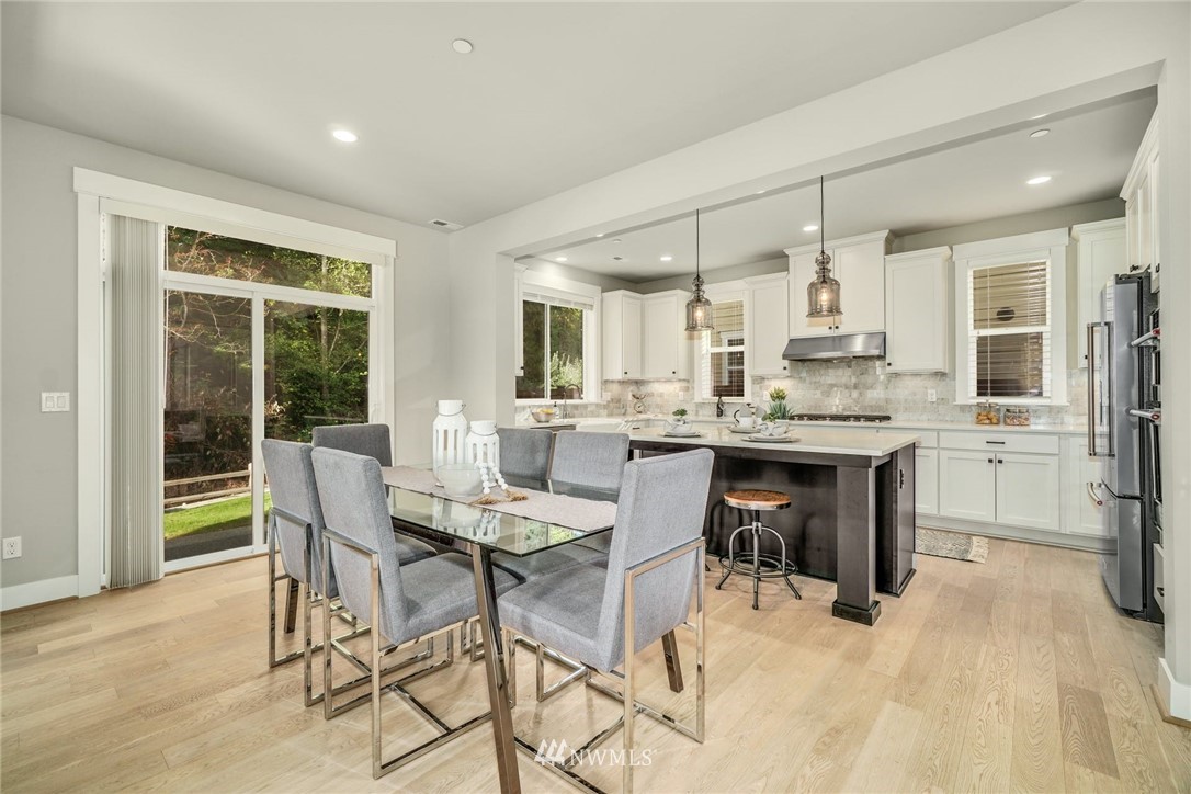 3318 238th Place Southeast Bothell, WA 98021 - Photo 10 of 36 a kitchen with kitchen island a dining table and chairs