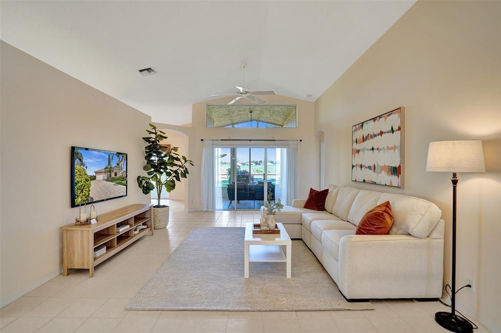 7219 Modena Drive Boynton Beach, FL 33437 - Photo 14 of 47 a living room with furniture a chandelier and a flat screen tv
