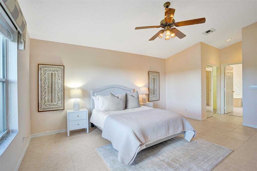7219 Modena Drive Boynton Beach, FL 33437 - Photo 21 of 47 a bedroom with a bed and a chandelier