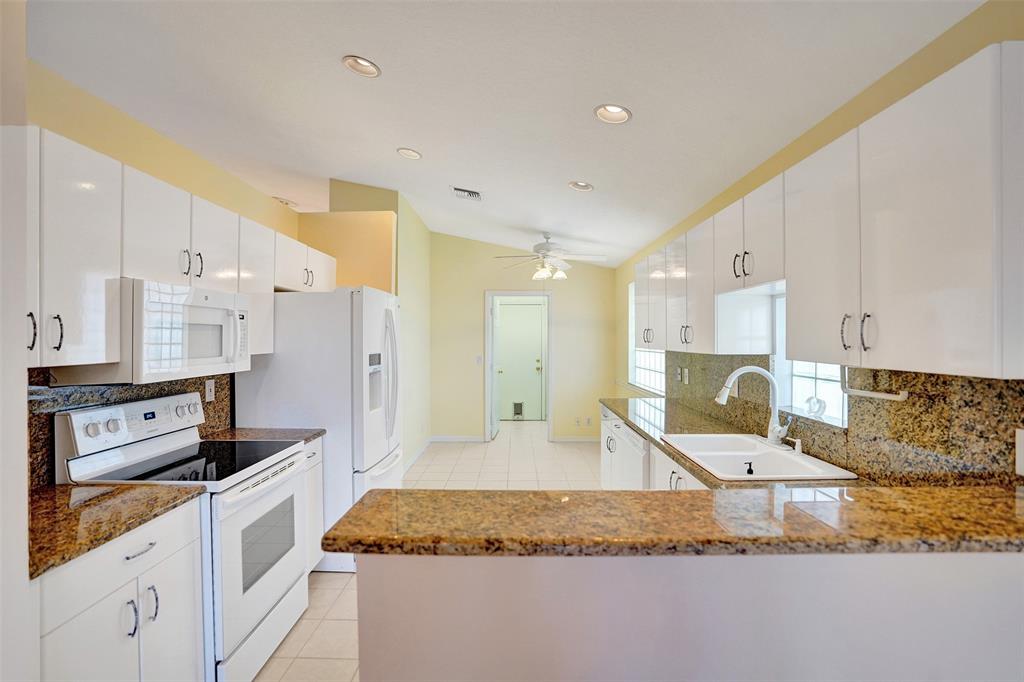 7219 Modena Drive Boynton Beach, FL 33437 - Photo 7 of 47 a kitchen with stainless steel appliances granite countertop a sink stove and refrigerator
