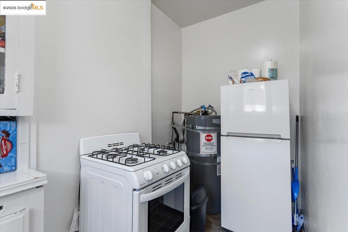 498 25th Street Oakland, CA 94612 - Photo 26 of 44 a white refrigerator freezer and a stove sitting inside of a kitchen