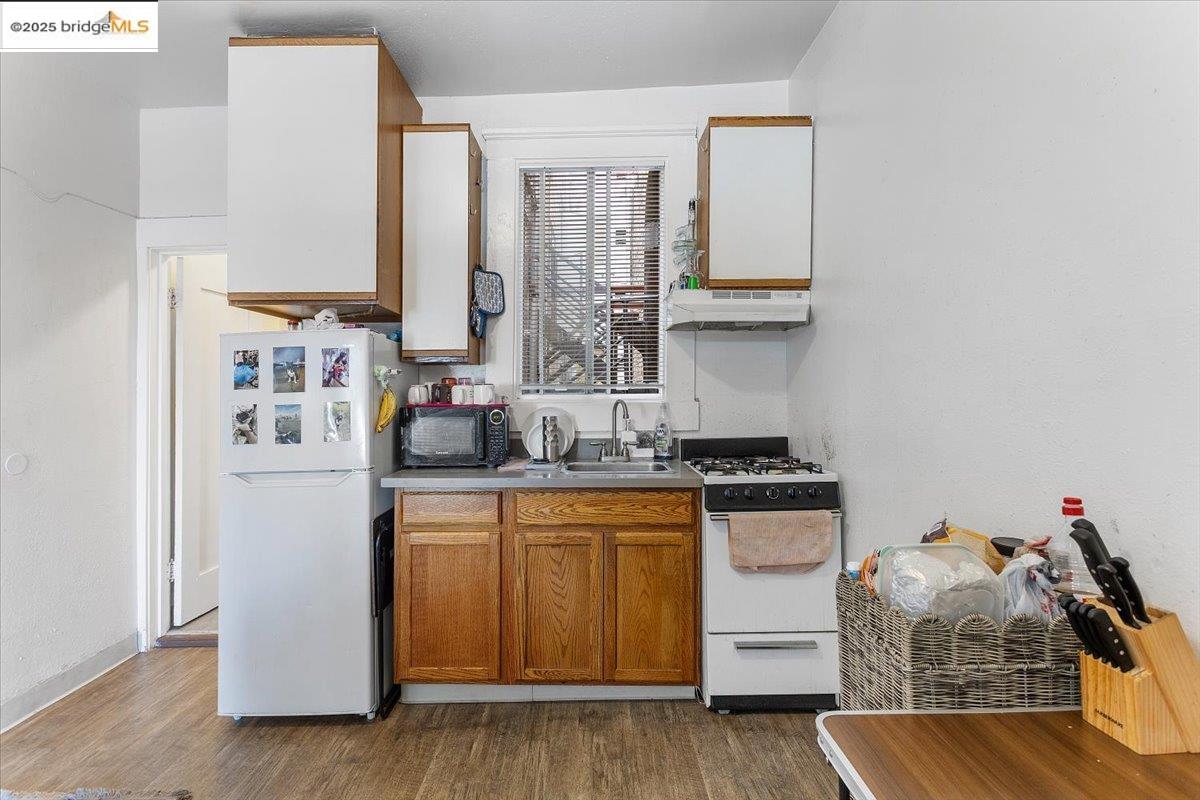 498 25th Street Oakland, CA 94612 - Photo 10 of 44 a kitchen with a refrigerator and a stove