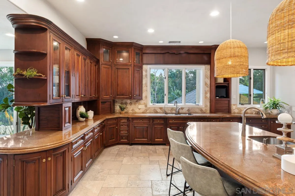 6281 Avenida Loma De Oro Rancho Santa Fe, CA 92067 - Photo 19 of 40 a kitchen with kitchen island granite countertop a sink and a stove