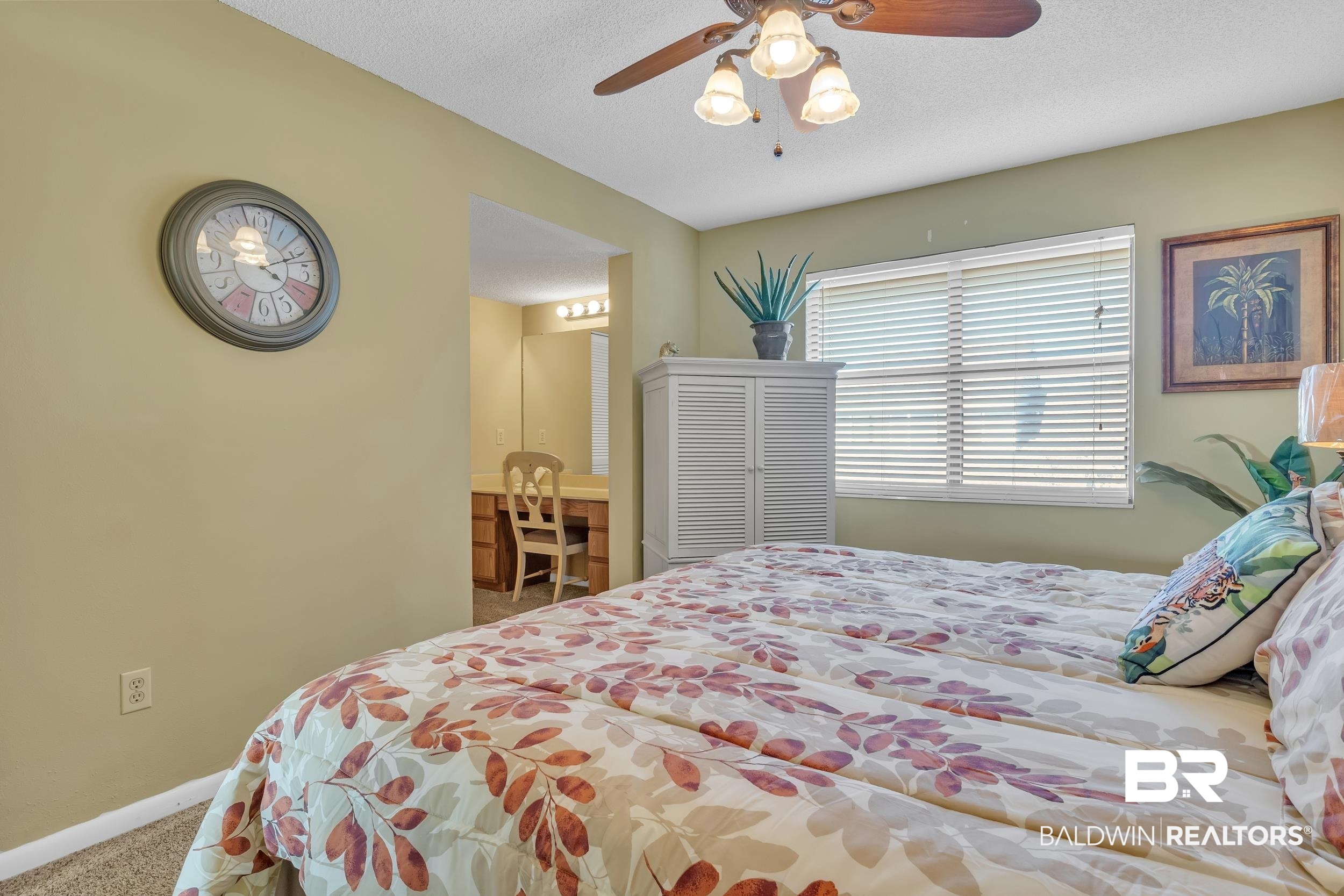 3256 Loop Road, Unit 2 Orange Beach, AL 36561 - Photo 23 of 25 Carpeted room featuring a ceiling fan with integrated lighting, a window with horizontal blinds, and a built-in wood-finish vanity with a mirror and lighting
