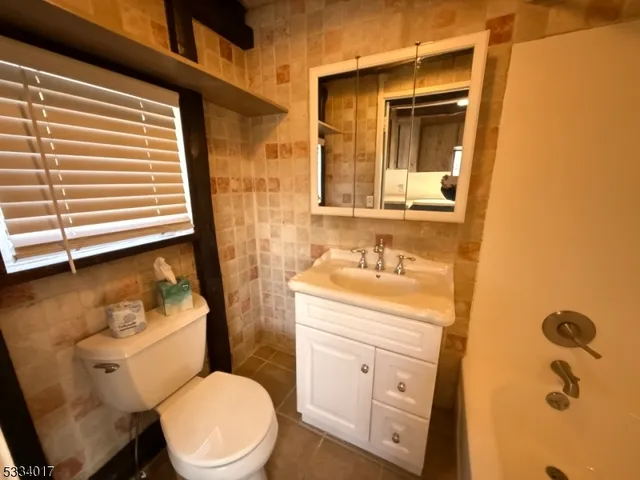 a bathroom with a granite countertop toilet sink and mirror
