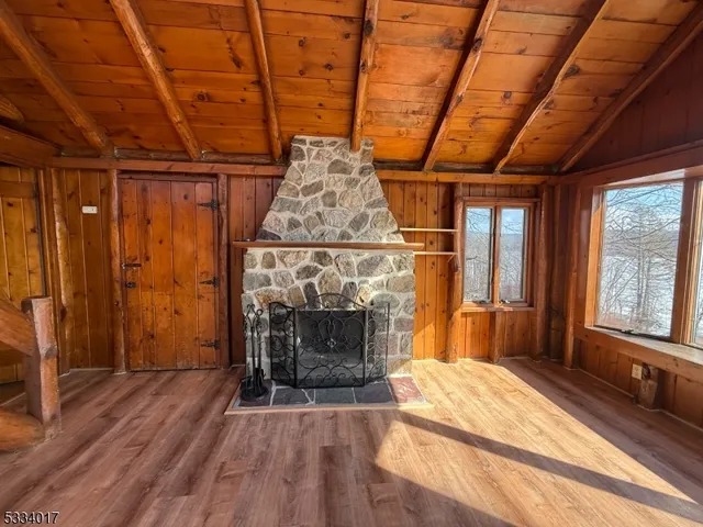 a view of a livingroom with wooden floor and a fireplace