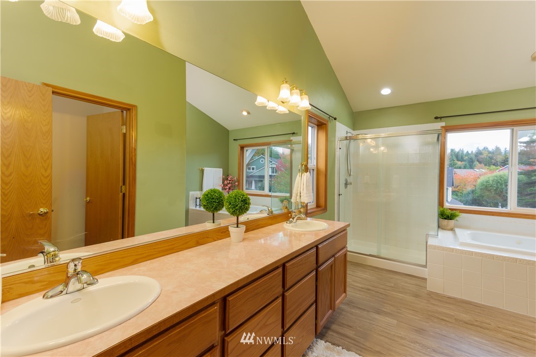 1220 Southwest 12th Street North Bend, WA 98045 - Photo 12 of 25 a bathroom with a double vanity sink a large mirror and a bathtub