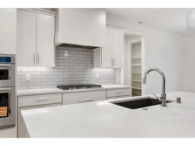 a kitchen with stainless steel appliances a sink and a stove
