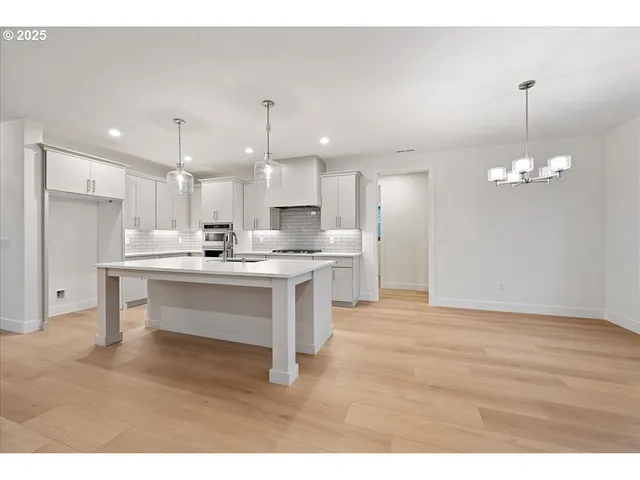 a open kitchen with kitchen island white cabinets and stainless steel appliances