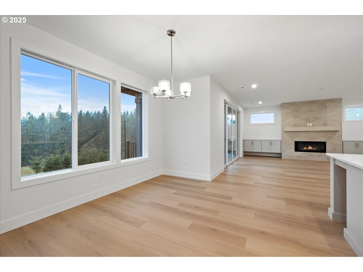 3510 North 11th Circle Ridgefield, WA 98642 - Photo 20 of 47 a view of an empty room with window wooden floor and a kitchen view
