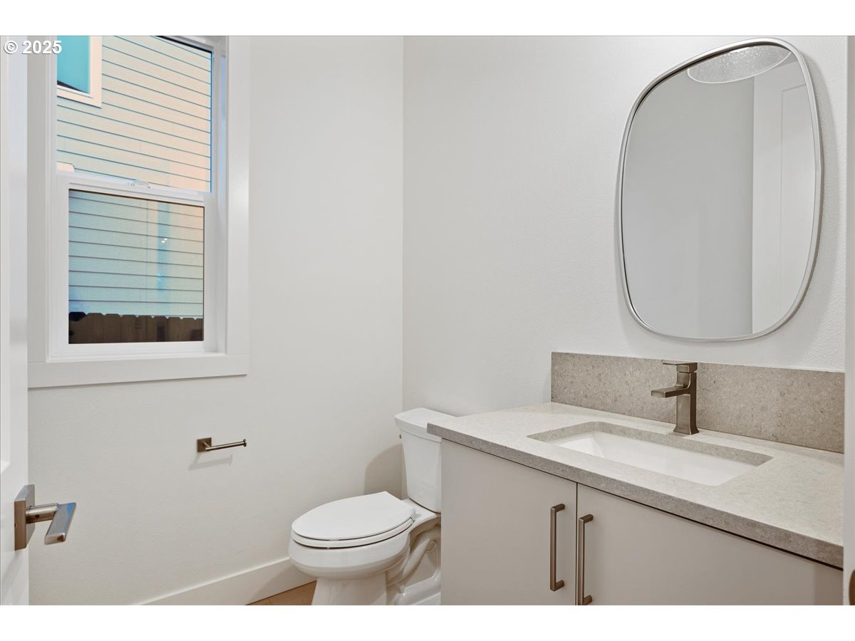 3510 North 11th Circle Ridgefield, WA 98642 - Photo 22 of 47 a bathroom with a toilet a sink a mirror and a window