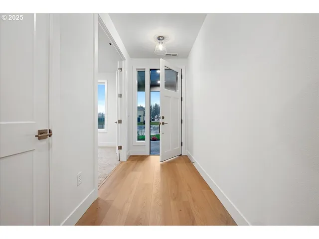 a view of a hallway with wooden floor
