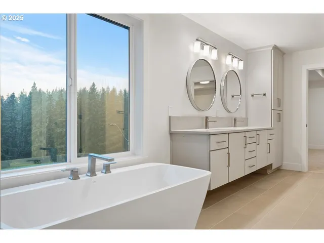 a bathroom with a double vanity sink mirror and bathtub