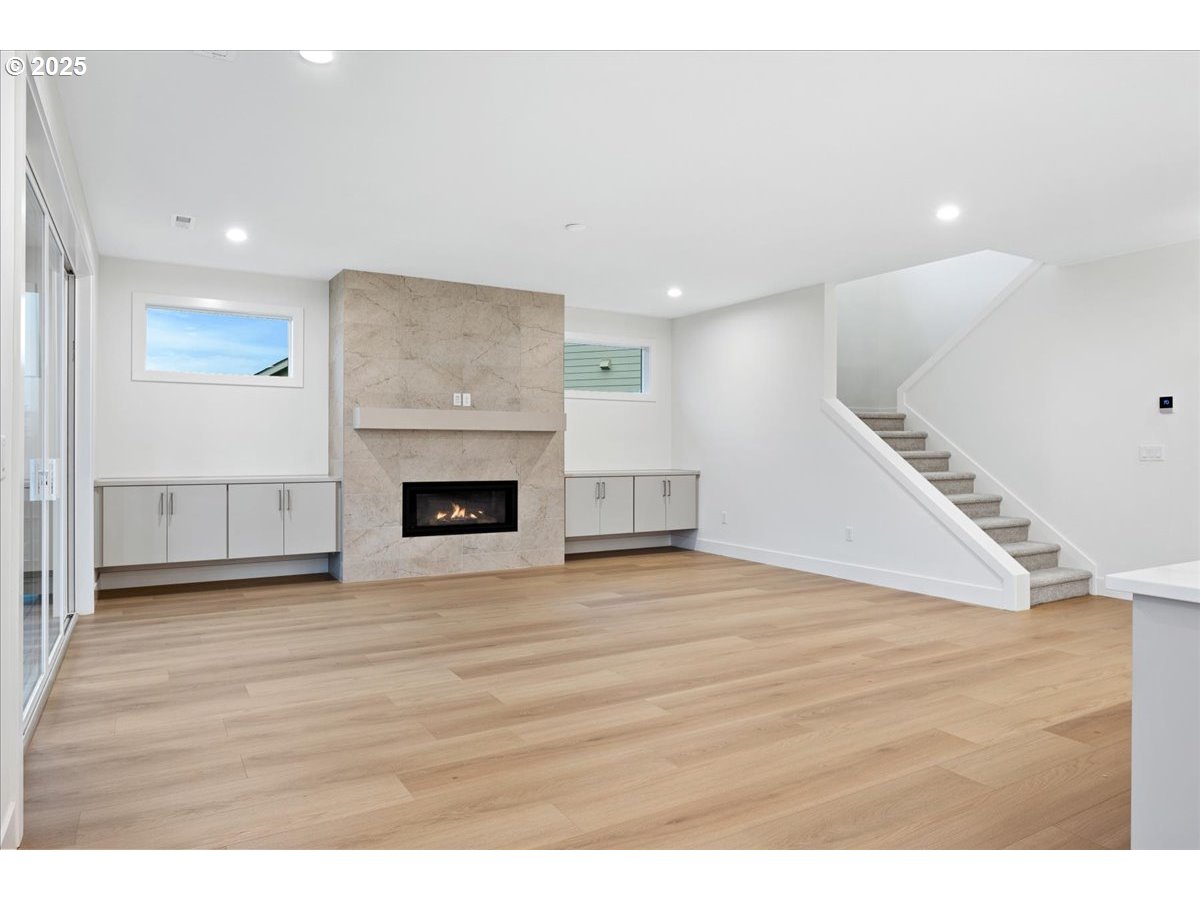 3510 North 11th Circle Ridgefield, WA 98642 - Photo 8 of 47 a view of an empty room with wooden floor fireplace and a window