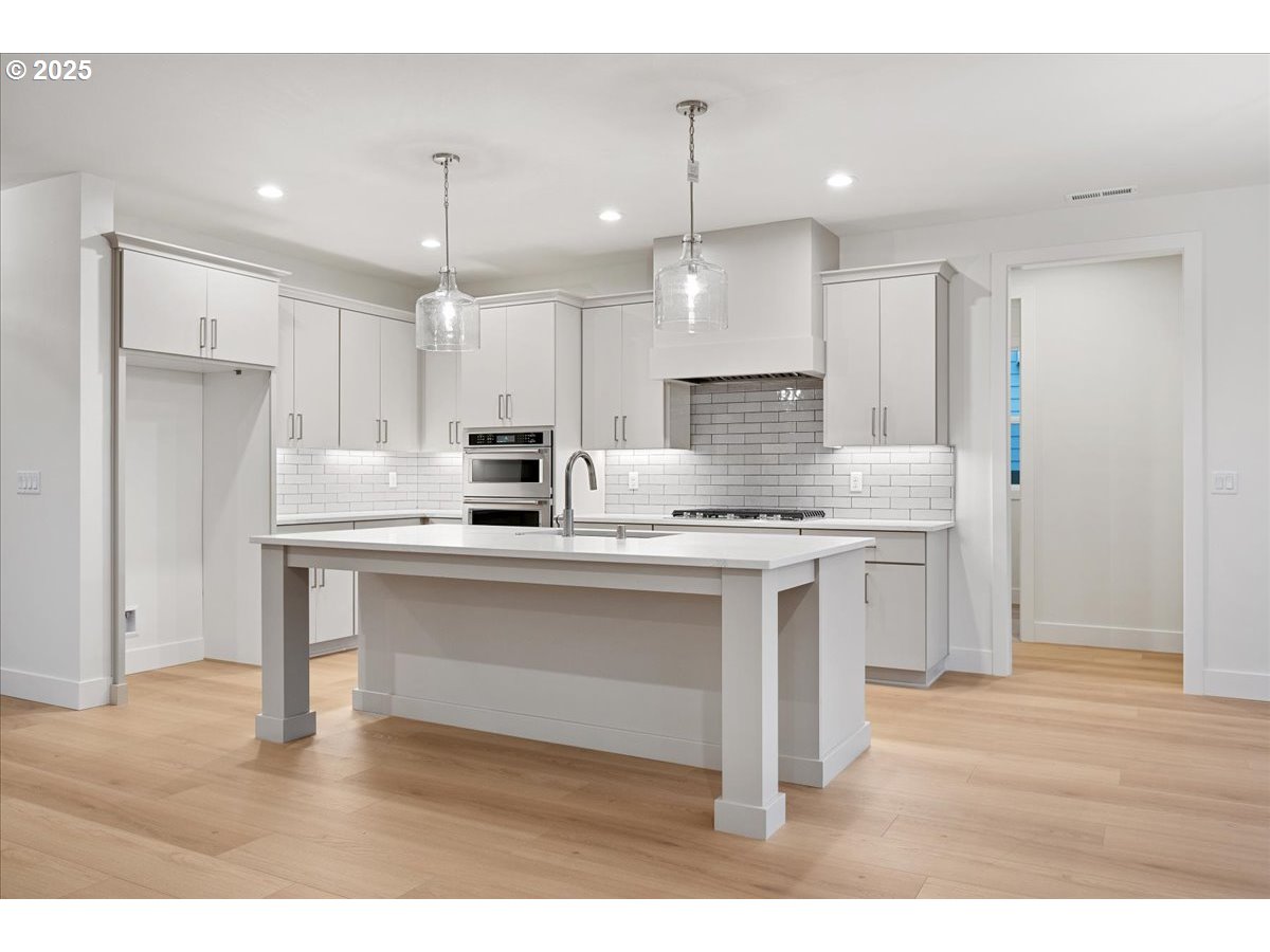 3510 North 11th Circle Ridgefield, WA 98642 - Photo 9 of 47 a kitchen with kitchen island granite countertop a sink cabinets and stainless steel appliances