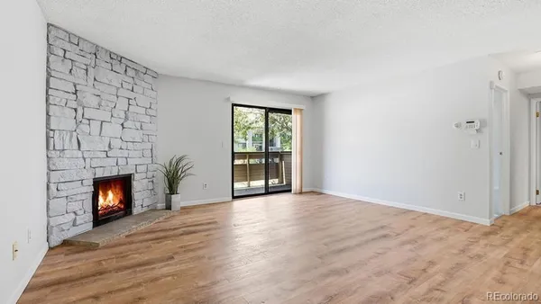 a view of an empty room with a fireplace and a window