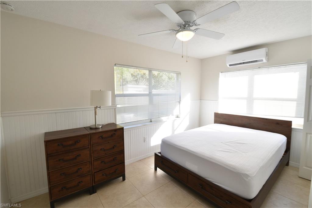 3125 Barrett Avenue Naples, FL 34112 - Photo 8 of 14 a bedroom with a bed a chandelier and a window