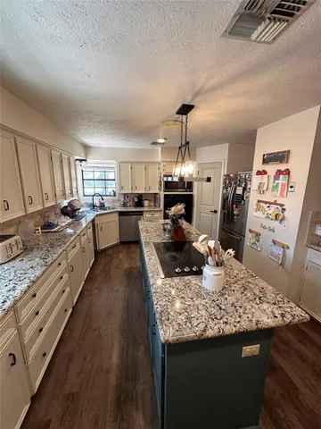 a large kitchen with sink stove and refrigerator