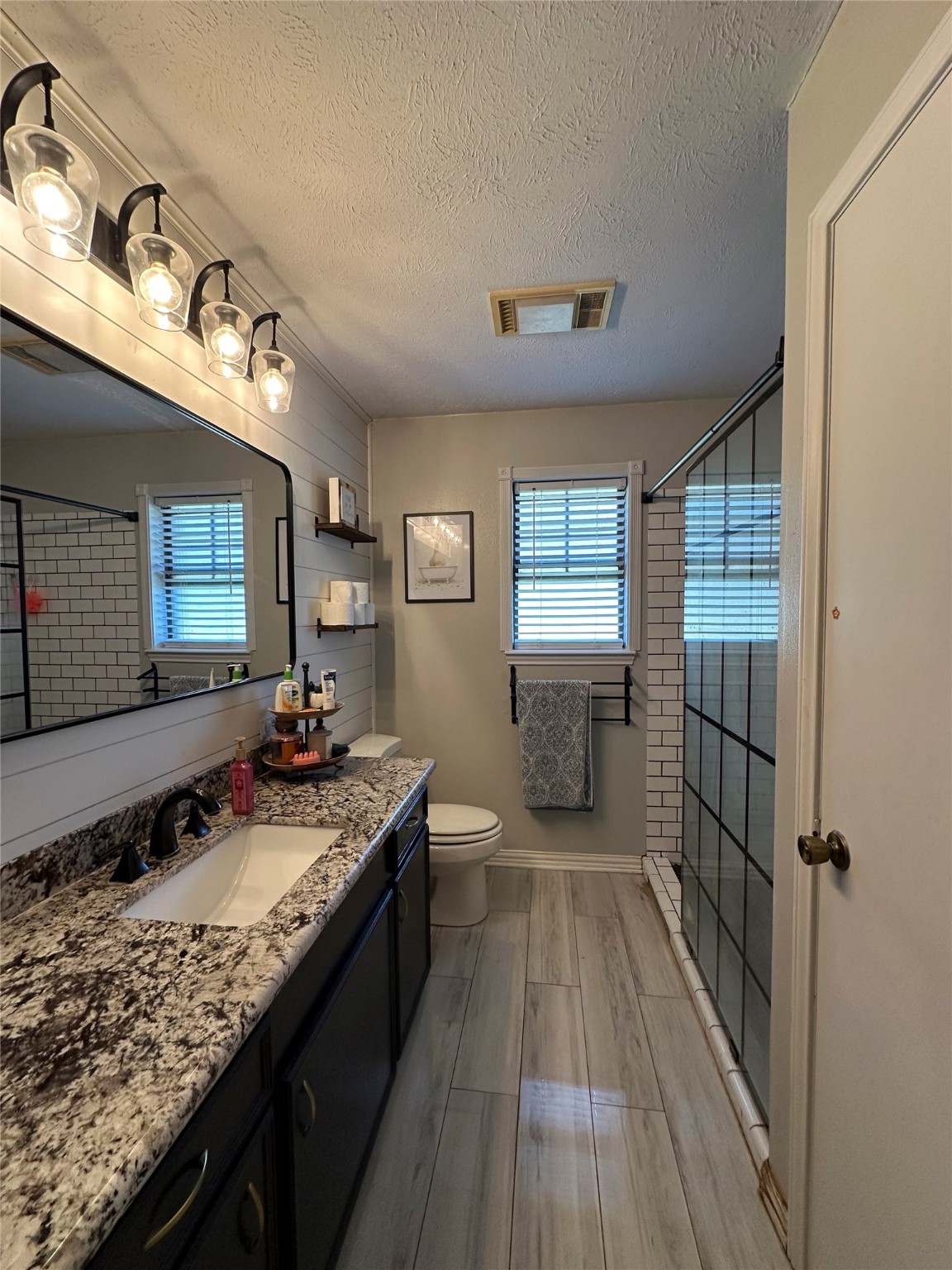2012 Wilson Road El Campo, TX 77437 - Photo 27 of 50 a bathroom with a granite countertop sink a mirror and a shower