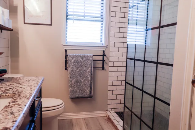 a bathroom with a granite countertop toilet and a shower