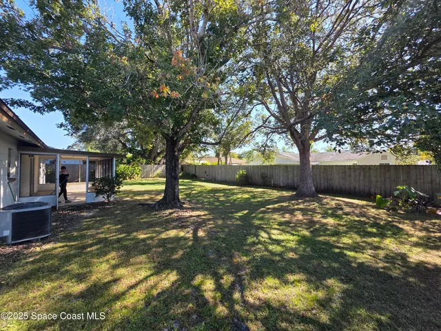 a backyard of a house with barbeque oven and table and chairs