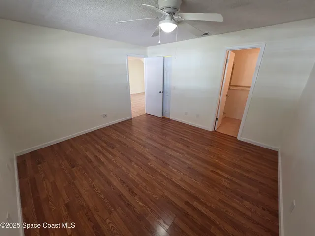 an empty room with wooden floor and hallway