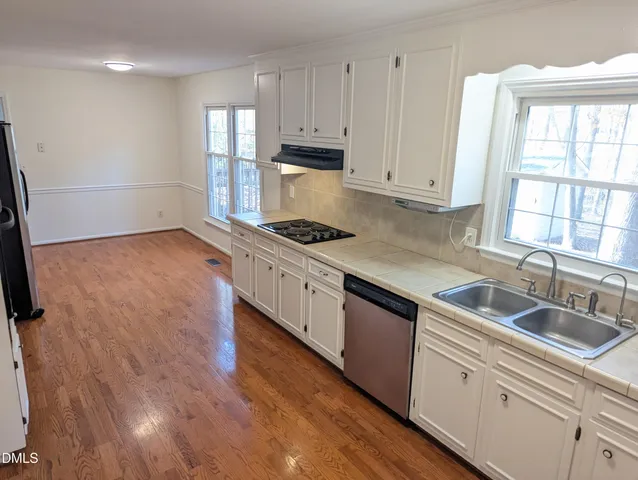 a kitchen with stainless steel appliances granite countertop a sink stove and cabinets