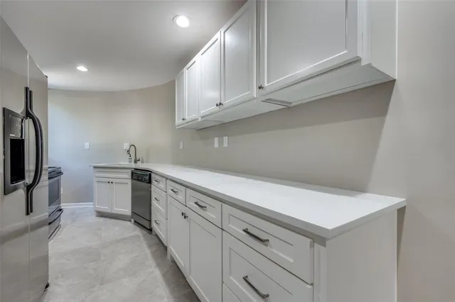 a kitchen with white cabinets stainless steel appliances and sink