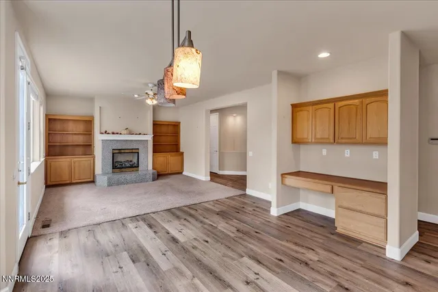 an empty room with windows and ceiling fan