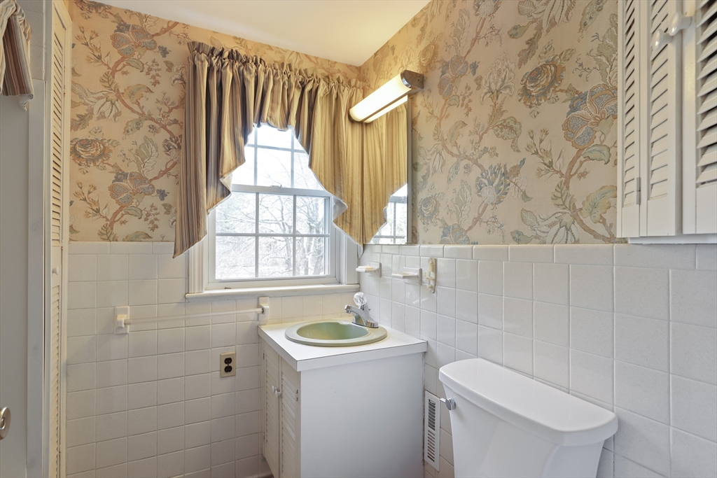22 Coolidge Road Walpole, MA 02081 - Photo 22 of 25 a bathroom with a sink a toilet and a shower curtain