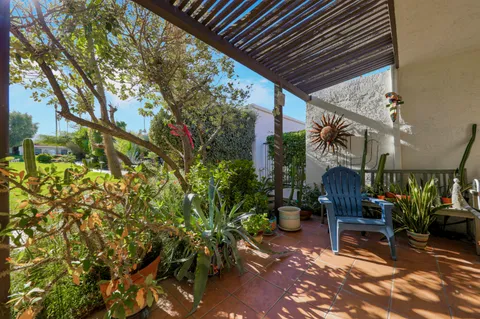 a view of a patio with table and chairs and potted plants