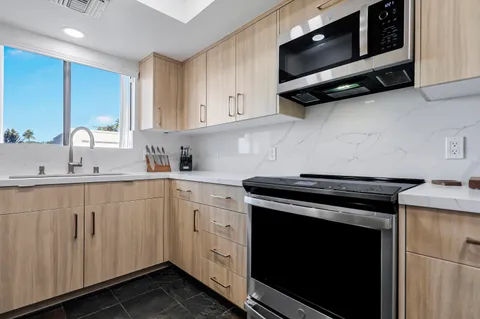 a kitchen with stainless steel appliances a stove a microwave sink and cabinets