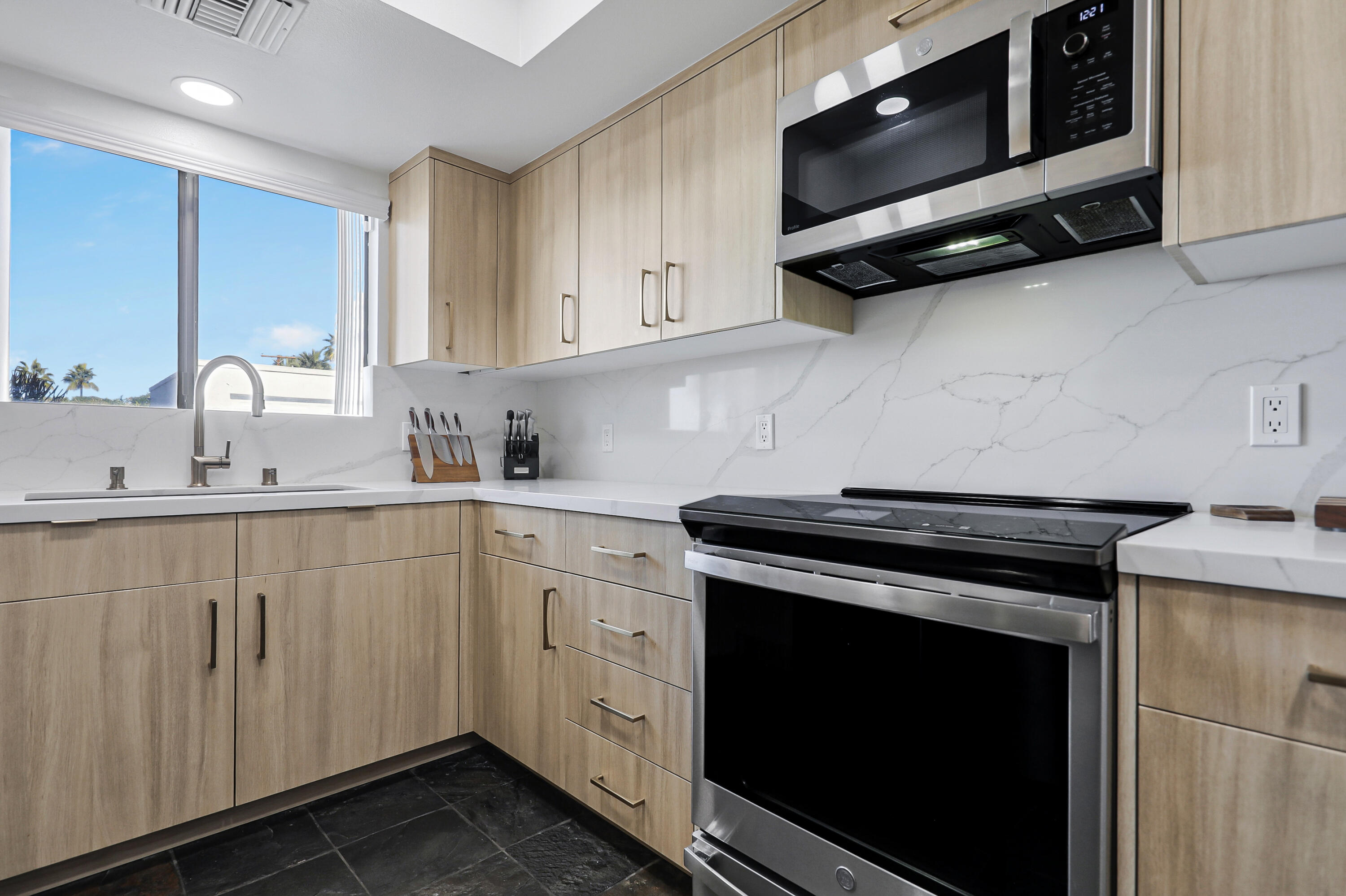 45760 Ocotillo Drive Palm Desert, CA 92260 - Photo 2 of 29 a kitchen with stainless steel appliances a stove a microwave sink and cabinets