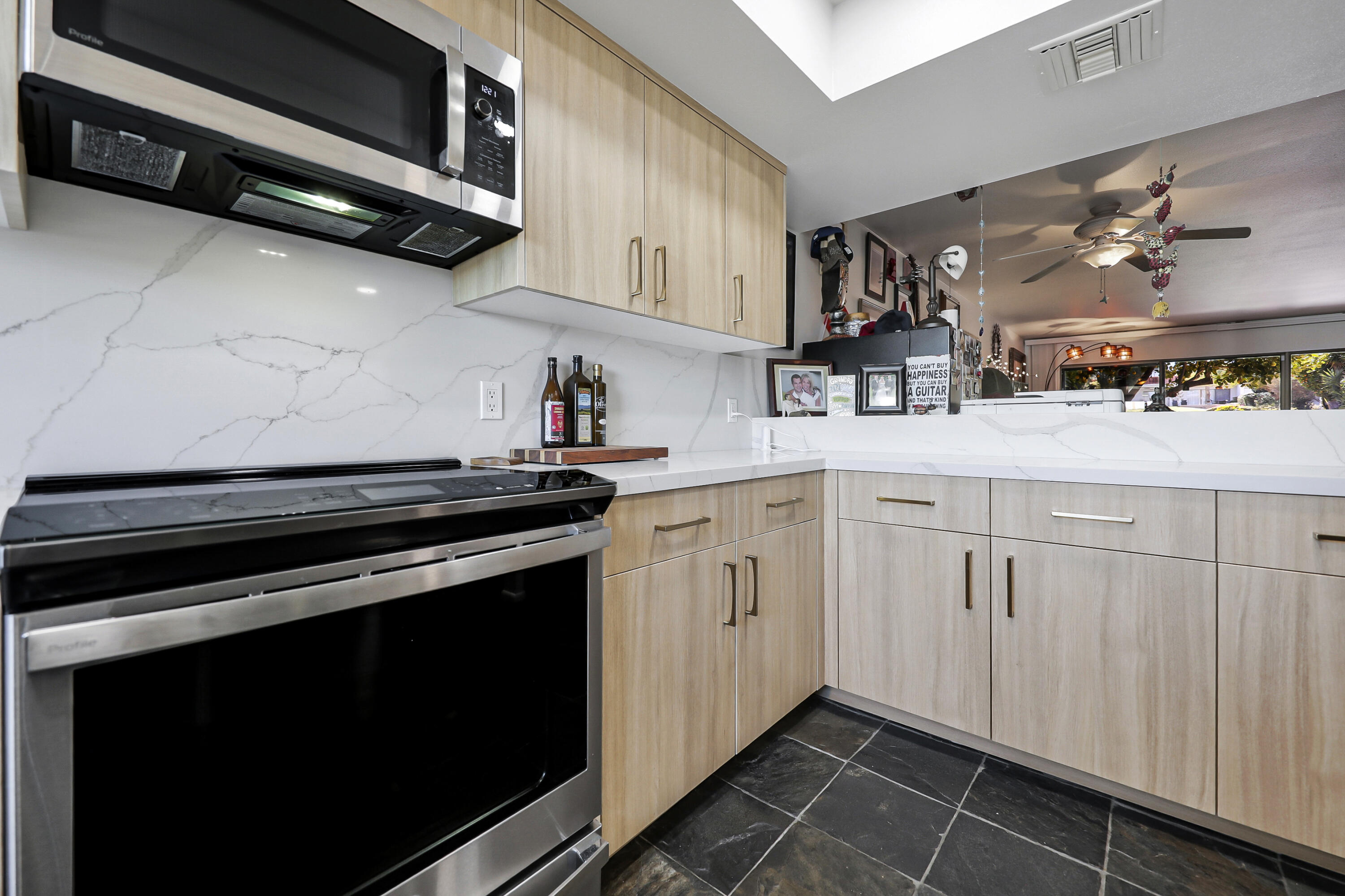 45760 Ocotillo Drive Palm Desert, CA 92260 - Photo 4 of 29 a kitchen with stainless steel appliances a stove a microwave and cabinets