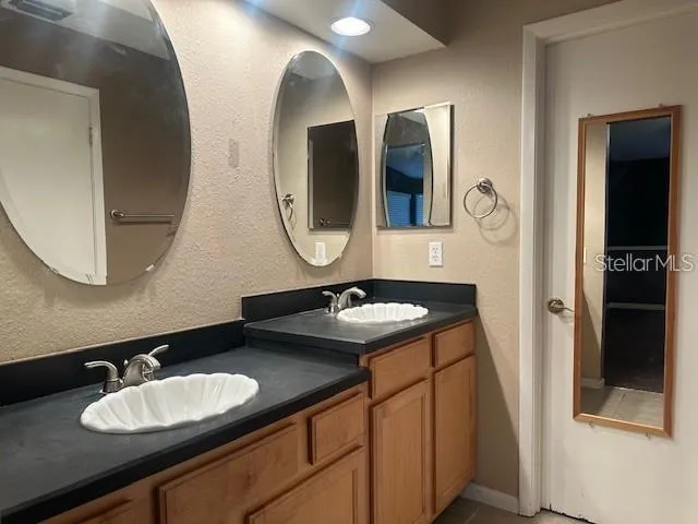 a bathroom with a granite countertop double vanity sinks and a mirror