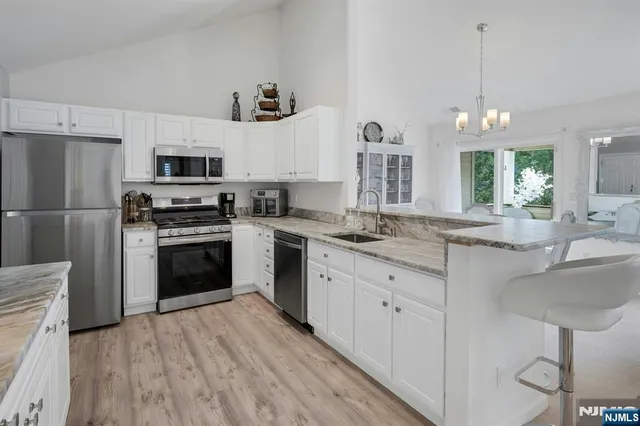 a kitchen with granite countertop a sink stainless steel appliances and counter space