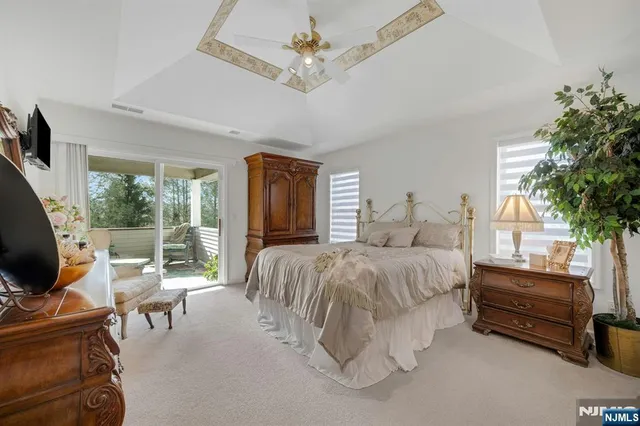 a spacious bedroom with a bed and a flat tv screen