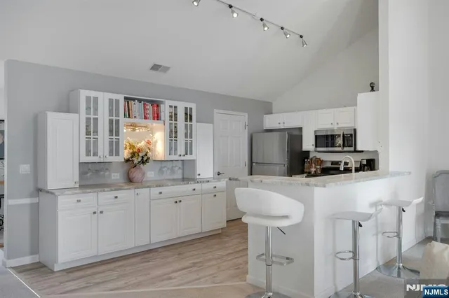 a kitchen with stainless steel appliances granite countertop a sink and a refrigerator