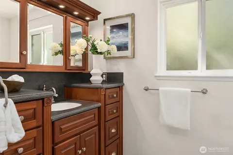 a bathroom with a sink a mirror and a window