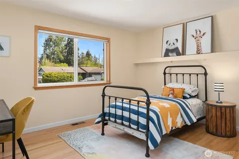 a bedroom with a bed and wooden floor