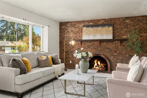 a living room with furniture a fireplace and a large window