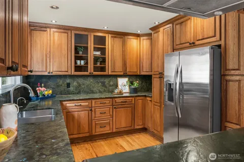 a kitchen with stainless steel appliances granite countertop a refrigerator and a sink
