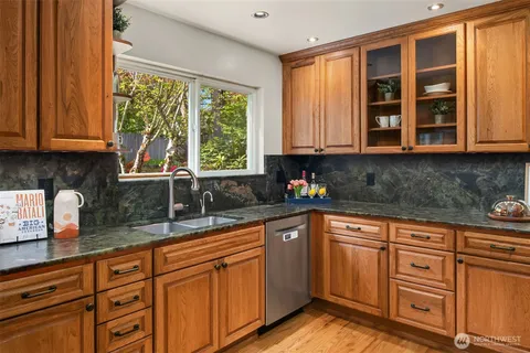 a kitchen with granite countertop wooden cabinets a sink and a window