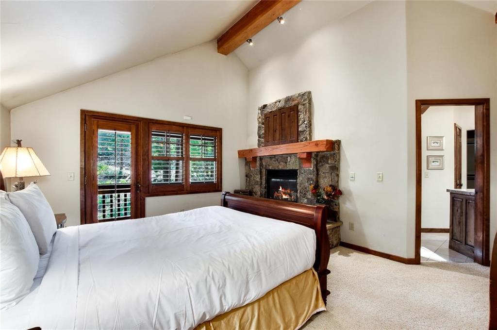 1050 4 O Clock Road Breckenridge, CO 80424 - Photo 28 of 35 a bedroom with a bed and a fireplace