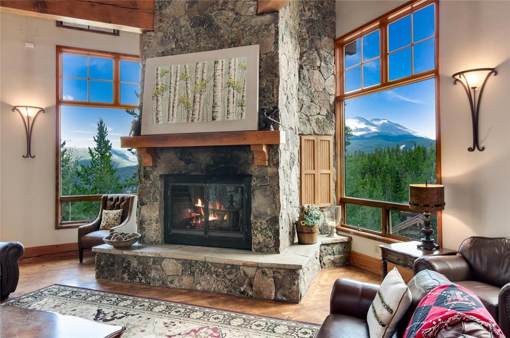 1050 4 O Clock Road Breckenridge, CO 80424 - Photo 8 of 35 a living room with furniture a fireplace and a floor to ceiling window