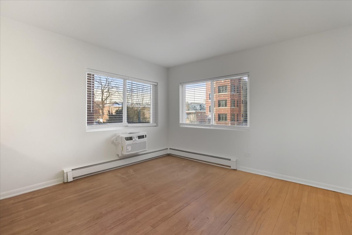 7357 North Winchester Avenue, Unit 2F Chicago, IL 60626 - Photo 6 of 12 an empty room with wooden floor and windows