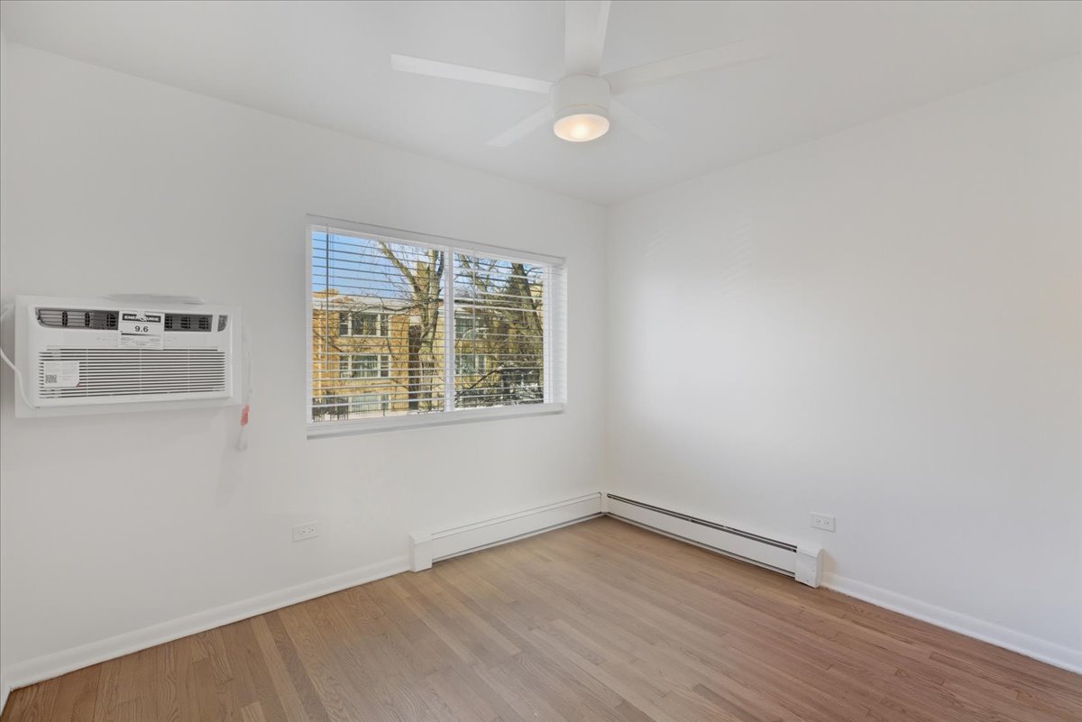 7357 North Winchester Avenue, Unit 2F Chicago, IL 60626 - Photo 7 of 12 an empty room with wooden floor and windows