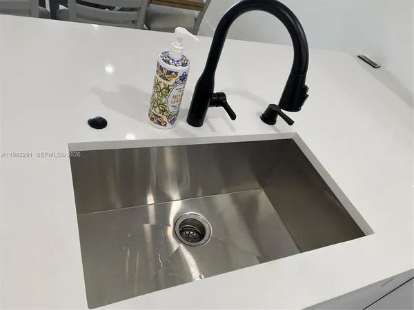 a view of a kitchen with a sink and dishwasher with wooden floor