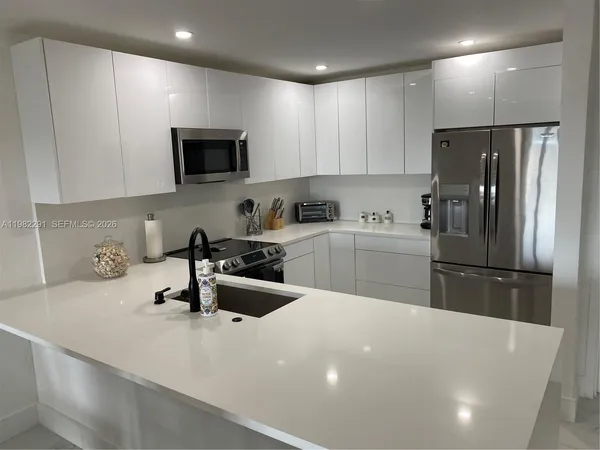 a kitchen with a sink a refrigerator and cabinets
